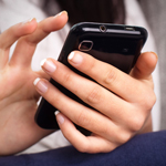Closeup of woman entering information on her mobile phone.