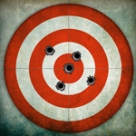 Target with a cluster of bullet holes around the bulls eye.