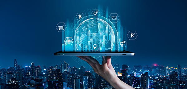 Various technology icons sitting on laptop with a city skyline in background.