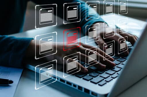 person typing on laptop with file icons floating over image