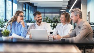 Small business team discussing cybersecurity initiatives and business technology in a modern office