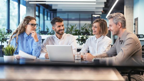 Small business team discussing cybersecurity initiatives and business technology in a modern office